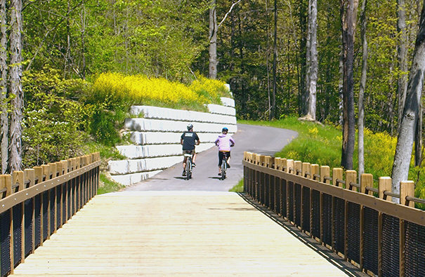 Cyclists crossing a pedestrian bridge on the Spoonville Trail
